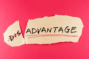 Torn paper showing the word "disadvantage," highlighting a challenge or unfavorable situation.