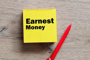 A signed document marked "earnest money," indicating a buyer's commitment in a property purchase.