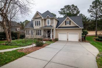 Two story suburban house with a two car garage and a concrete driveway